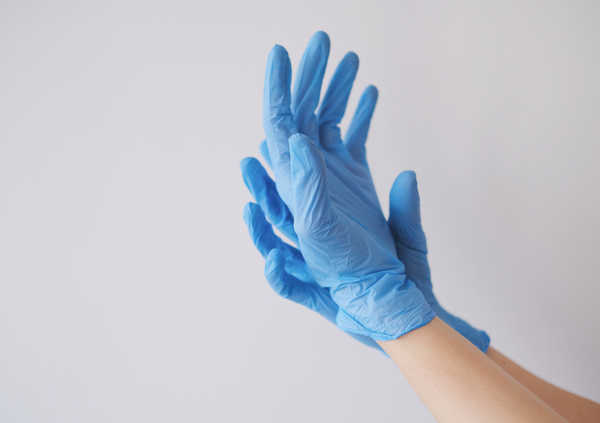 پوشیدن دستکش برای آلوده نشدن دست ها در حال تعویض پوشک بیمار